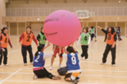 日本女子体育大学 生涯スポーツ演習（ニュースポーツ）の授業の一コマ。キンボールなどのゲームを学生自身が楽しみながら学びます。